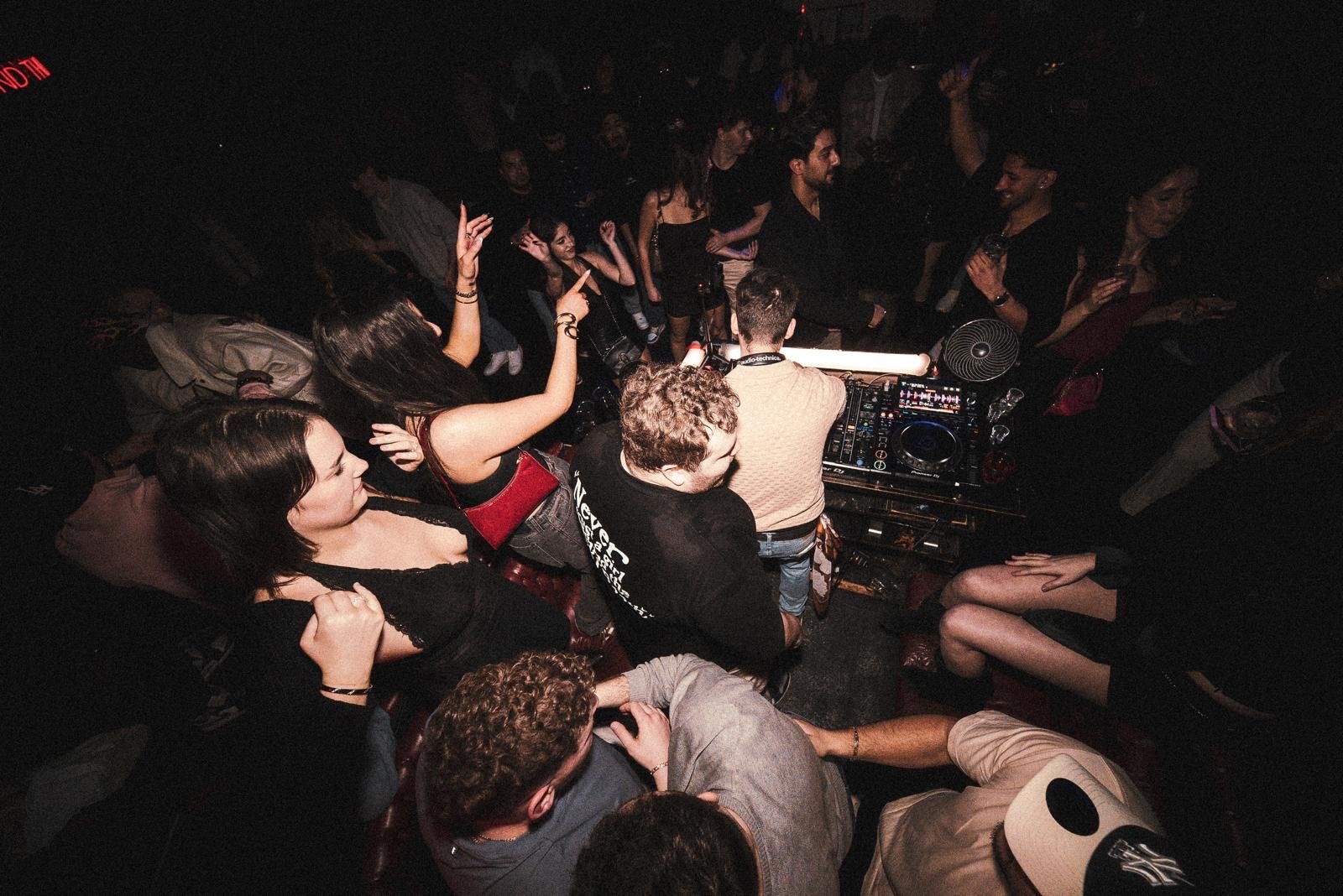 Overhead view of guests dancing packed around the DJ booth
